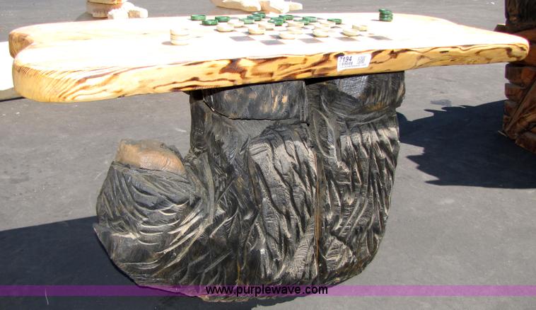 image for item 7194 Bear on its back hold up a checkers table with two stools chainsaw art carving