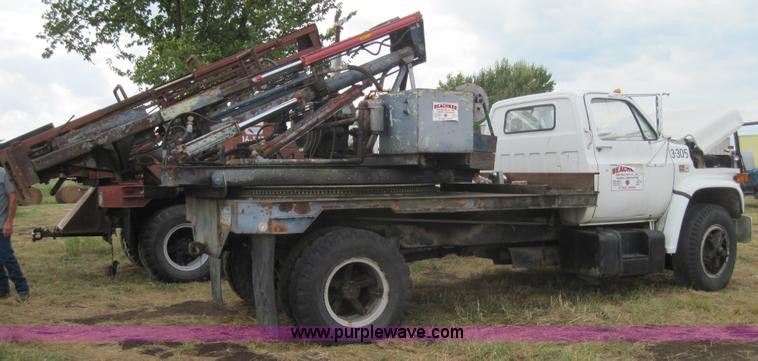 image for item 3180 1989 GMC C7000 flatbed truck with hydraulic post driver