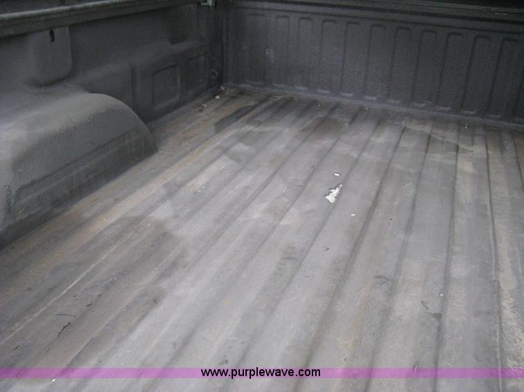 image for item 8134 2004 GMC Sierra 1500 long bed pickup truck with topper