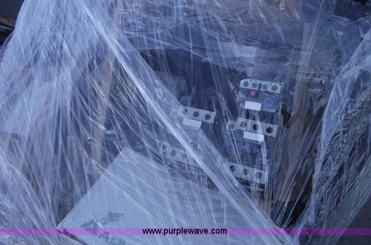 image for item E9571 Three wheel dump cart filled with assorted industrial electric parts