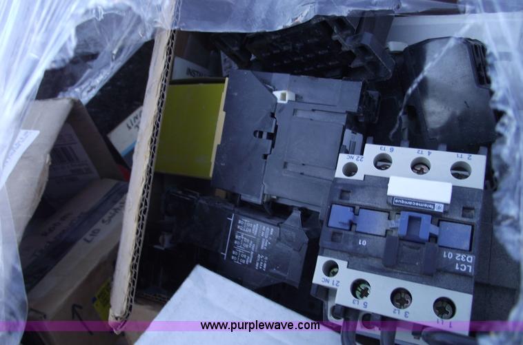 image for item E9571 Three wheel dump cart filled with assorted industrial electric parts