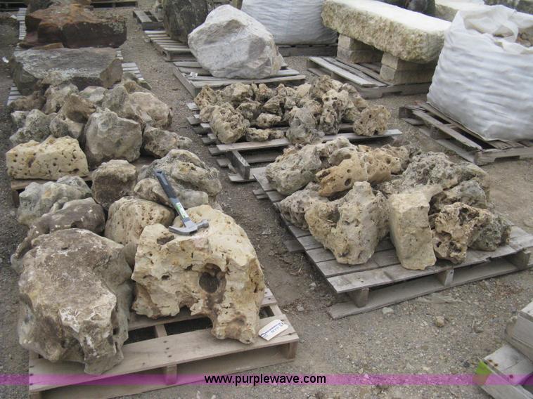 Various sizes of weathered holey limestone boulders on pallets in ...