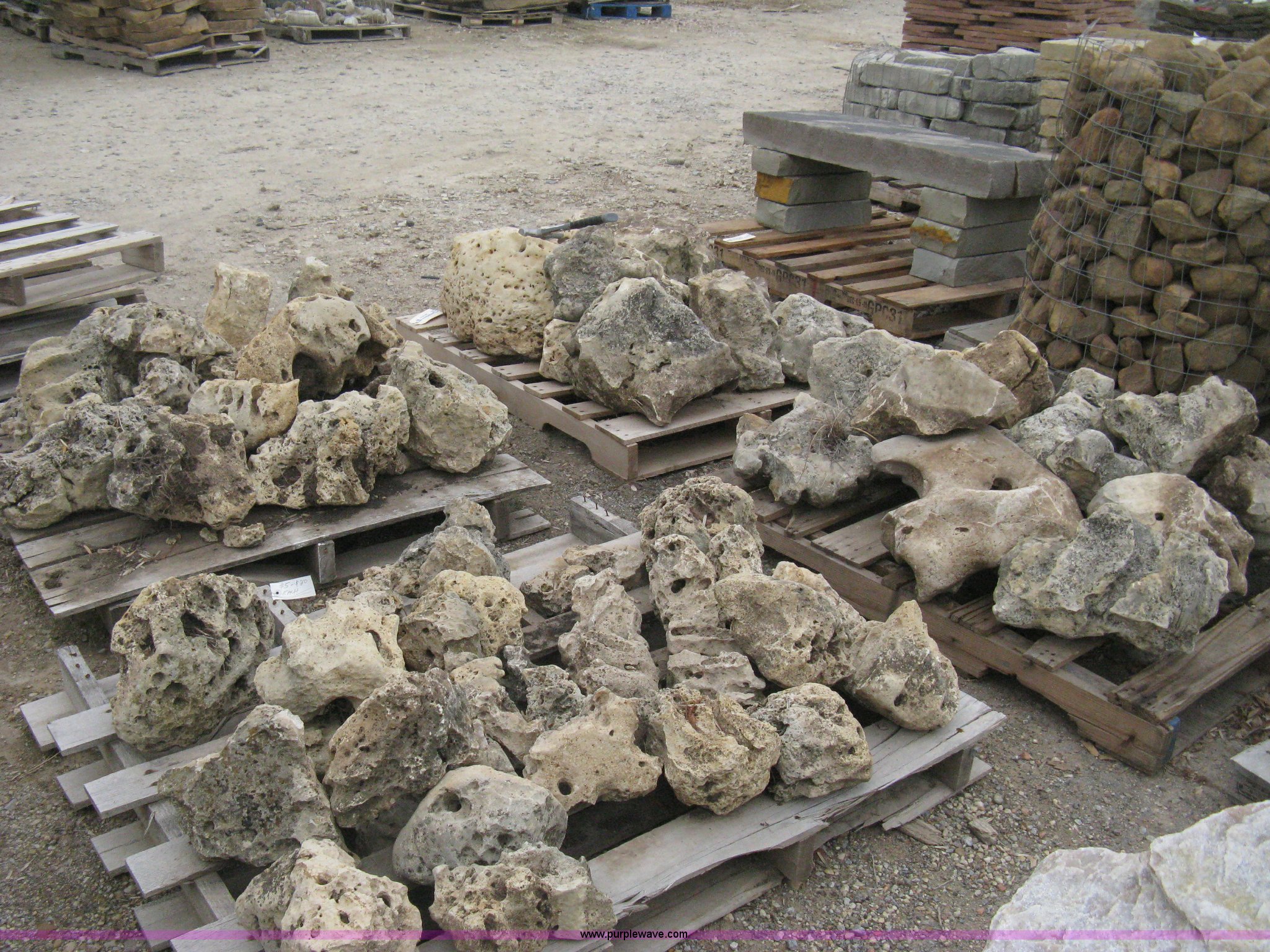 Various sizes of weathered holey limestone boulders on pallets in ...