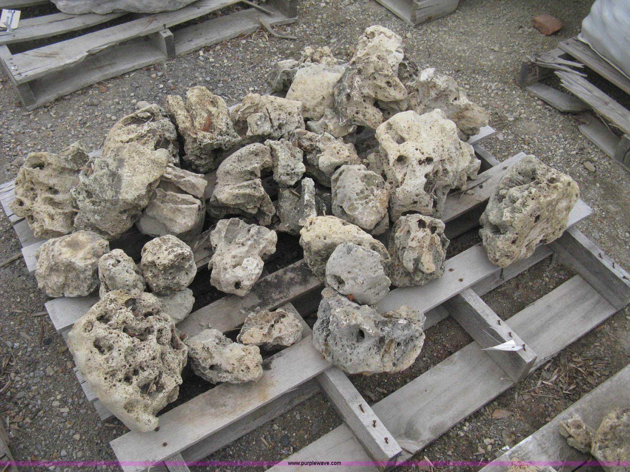 Various sizes of weathered holey limestone boulders on pallets in ...