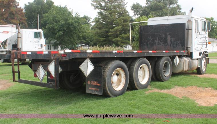 image for item I7895 1982 International Eagle cab over tri axle flatbed truck