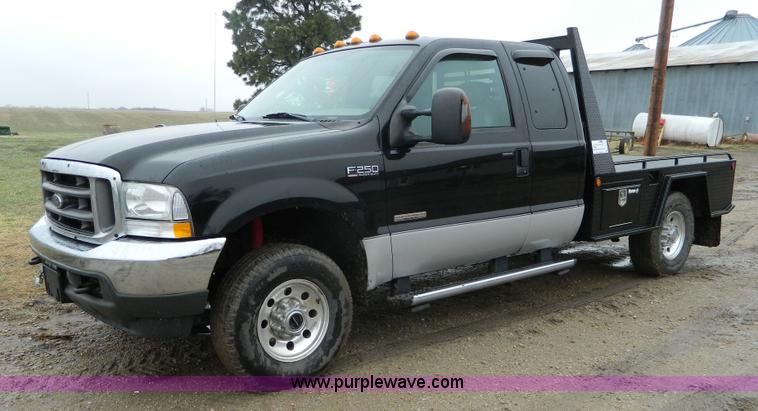 image for item D6119 2004 Ford F250 Super Duty SuperCab flatbed pickup truck