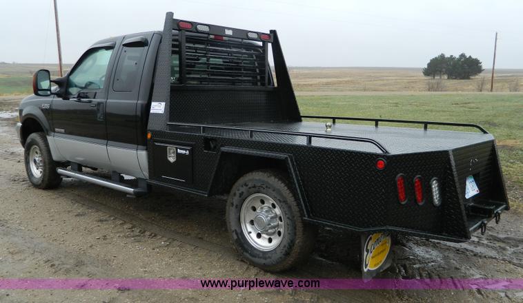 image for item D6119 2004 Ford F250 Super Duty SuperCab flatbed pickup truck