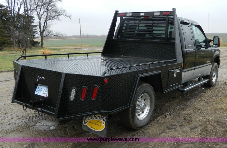 image for item D6119 2004 Ford F250 Super Duty SuperCab flatbed pickup truck