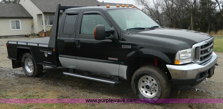 image for item D6119 2004 Ford F250 Super Duty SuperCab flatbed pickup truck