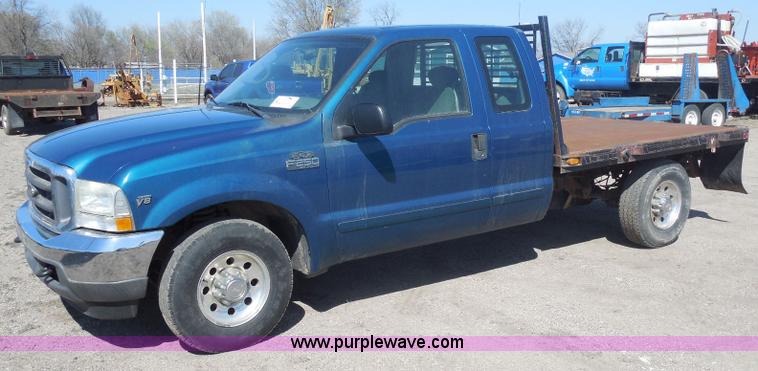 image for item E6311 2002 Ford F250 Super Duty SuperCab flatbed pickup truck