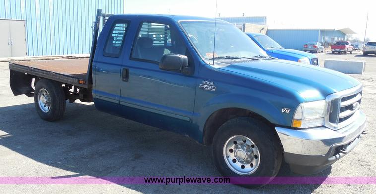 image for item E6311 2002 Ford F250 Super Duty SuperCab flatbed pickup truck