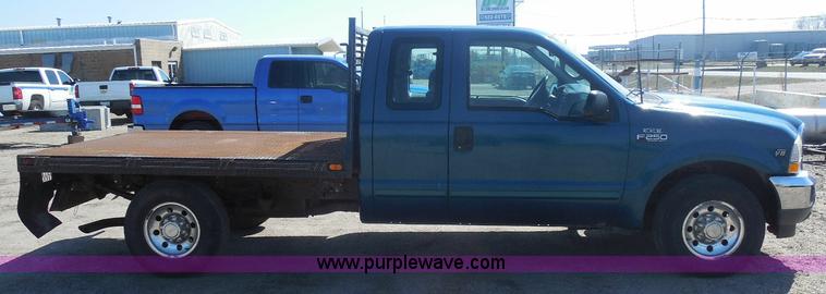 image for item E6311 2002 Ford F250 Super Duty SuperCab flatbed pickup truck