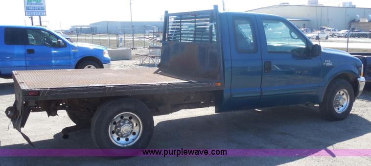 image for item E6311 2002 Ford F250 Super Duty SuperCab flatbed pickup truck