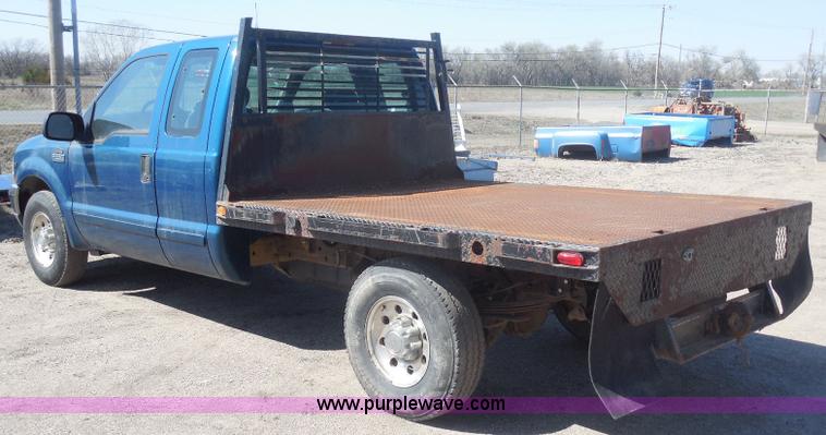 image for item E6311 2002 Ford F250 Super Duty SuperCab flatbed pickup truck