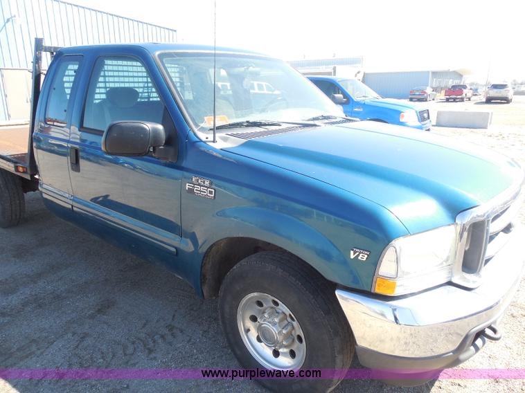 image for item E6311 2002 Ford F250 Super Duty SuperCab flatbed pickup truck