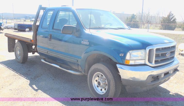 image for item E6312 2002 Ford F250 Super Duty SuperCab flatbed pickup truck