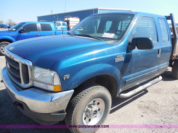 image for item E6312 2002 Ford F250 Super Duty SuperCab flatbed pickup truck