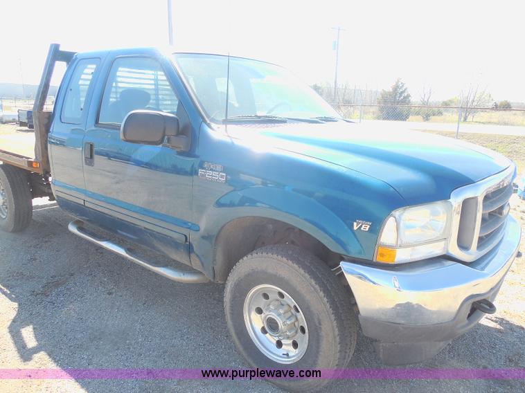 image for item E6312 2002 Ford F250 Super Duty SuperCab flatbed pickup truck