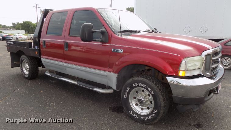 image for item DE7729 2002 Ford F250 Super Duty XLT Crew Cab flatbed pickup truck