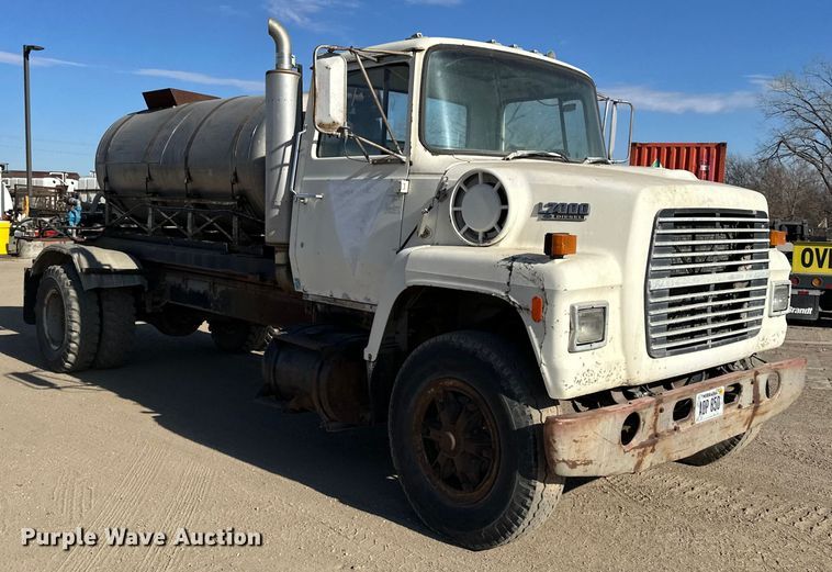 image for item ES1024 1985 Ford L7000 hook lift truck with tank