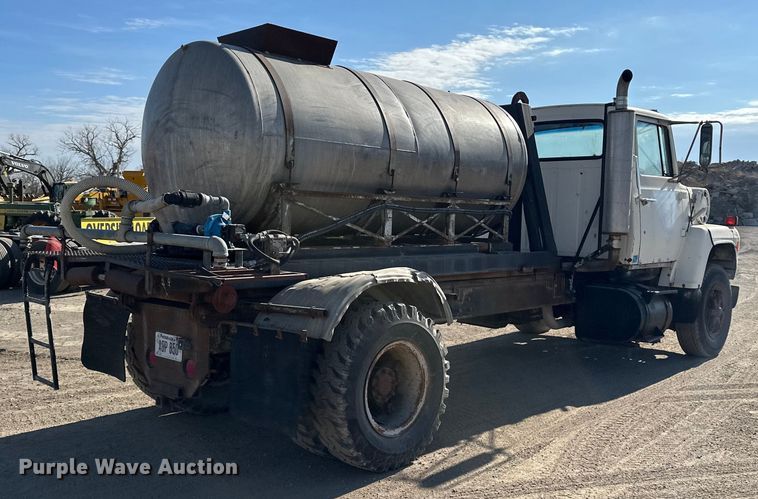 image for item ES1024 1985 Ford L7000 hook lift truck with tank